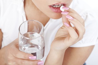 Young woman taking a pill