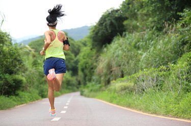 trail runner athlete running on forest trail.