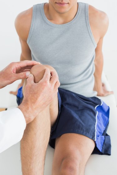 Close-up of a man getting his knee examined