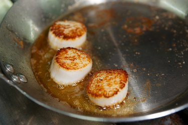 Scallops being seared on pan