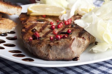 slice of grilled rump steak with green and pink pepper