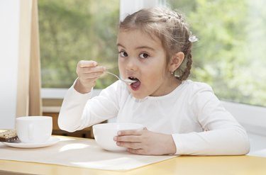 Little child eats yogurt