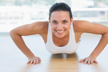 A fit woman does push-ups.