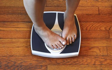 Woman on scale unhappy with her weight