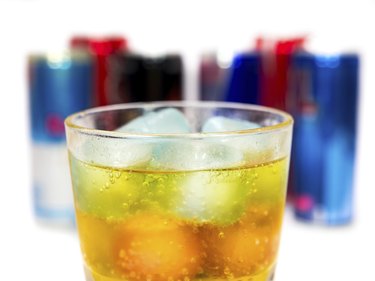 glass with ice and energy drinks on the background