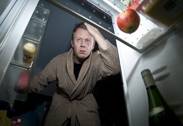 Man looks into the refrigerator for a snack