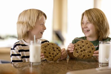 Boys having milk and cookies at table