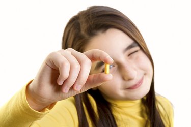 young girl holding capsule