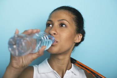 Female tennis player drinking water