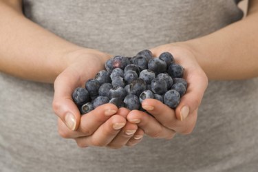 Woman holding fresh blueberries