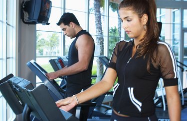 Man and woman exercising on exercise machine in a gymnasium