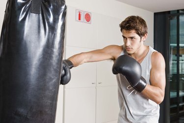 Man boxing on heavy bag at gym