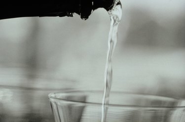 Liquid being poured from bottle to glass, close-up