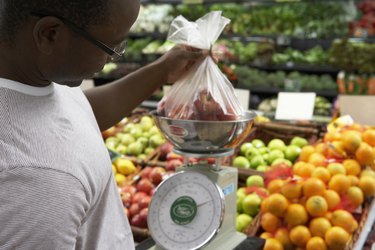 Man weighing apples in supermarket, close-up