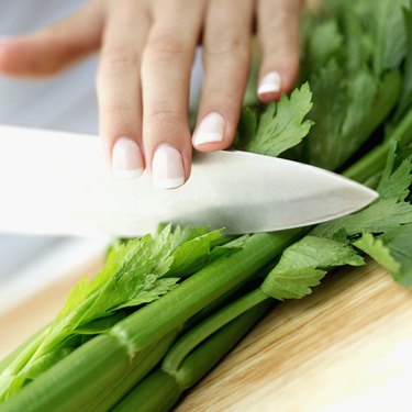 close-up of a woman's hand chopping celery