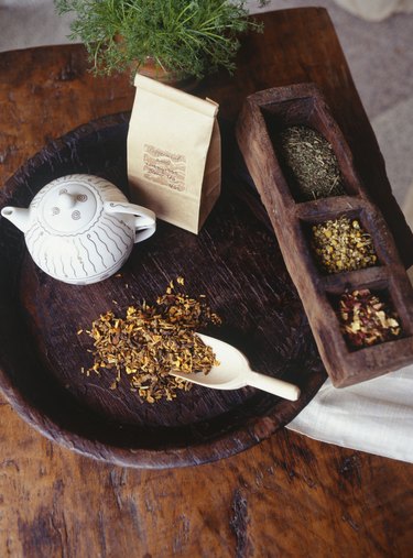 Teapot and peppermint tea lying on wooden tray, elevated view