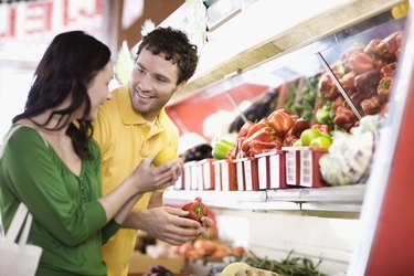 Couple grocery shopping for vegetables