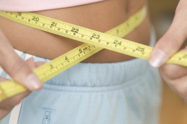 Closeup of teen girl measuring her waist