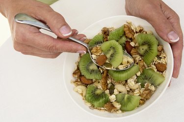 Woman holding spoonful of muesli, close up