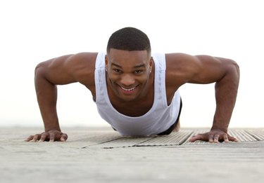 Close up portrait of a smiling man doing push ups