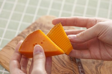 Hands pulling apart two pieces of cheese
