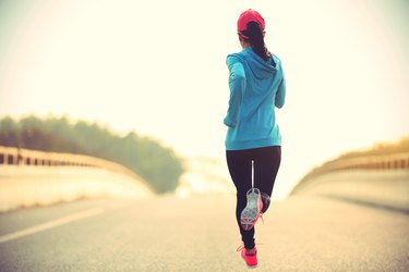 young fitness woman runner running on road