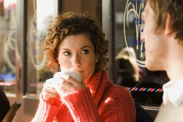 Young woman drinking a cup of tea in a sidewalk cafe