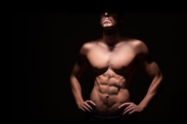 Muscular man with dark background.