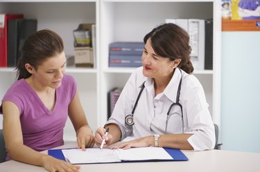 Doctor writing in patient's chart