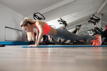 Woman make push-ups in gym