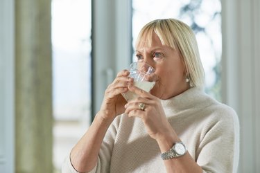 Older adult taking a sip from a glass of weight gain drink