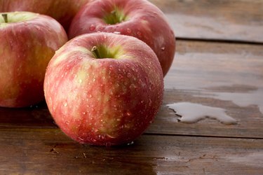 Honeycrisp apples on a wood background.