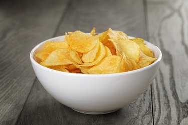organic potato chips in white bowl on wood table