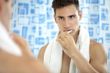 Man brushing teeth in front of mirror