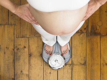 Pregnant woman standing on scales