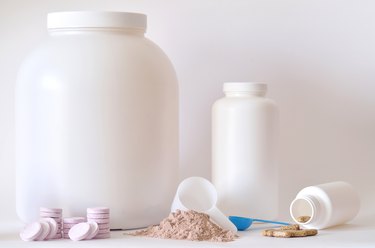Big jar of protein powder, bottle, pills and tablets