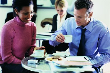 Two Business Colleagues Sitting in a Canteen Having a Cup of Coffee