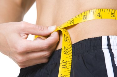 close up photo of a woman measuring her waist