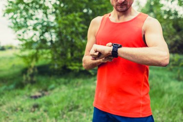 close-up of a male runner setting the time on a running watch