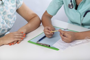 Doctor showing patient a syringe