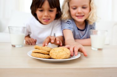 Adorable siblings eating biscuits
