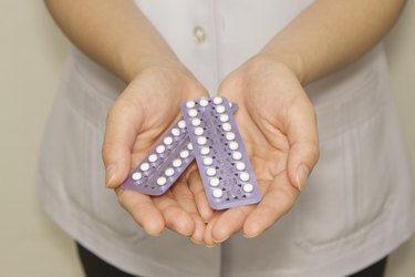 doctor's hand  holding the birth control pills