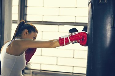 Attractive Female Punching A Bag With Boxing Gloves On