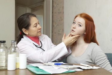 doctor touching neck of  girl
