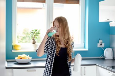 Thirsty young blond woman drinking milk