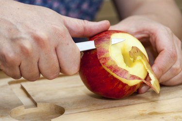 Hands peeling apple
