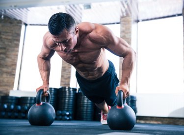 Muscular man doing push ups in gym