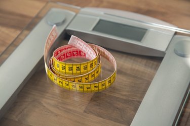 Measuring tape on bathroom scale.