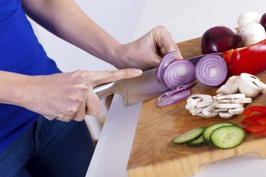 female hands chopping vegetables on a wooden board