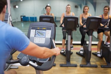 Man teaches Spinning Class to happy women